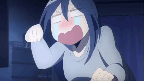 A woman sobbing at her desk at night while hammering her keyboard with both fists.